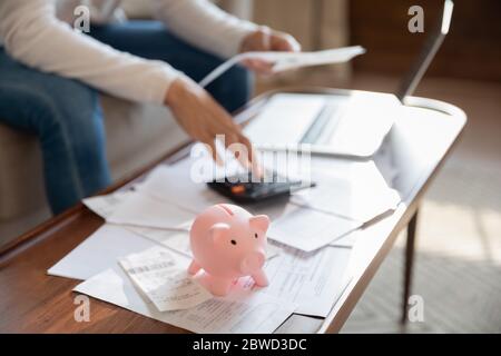 Gros plan de la femme calculer les dépenses d'économie dans la banque de piggy Banque D'Images