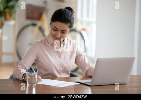Bonne femme d'affaires hindoue travaillant sur le projet seul au bureau. Banque D'Images