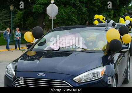 Winterset, Iowa, États-Unis. 31 mai 2020. Un pare-brise de voiture décoré d'une photo surdimensionnée d'un diplômé de l'école secondaire Winterset mène une gamme de voitures au palais de justice du comté de Madison dans le cadre d'une cérémonie de remise des diplômes en voiture le 31 mai, 2020.les diplômés et leurs familles ont reçu deux véhicules chacun et ont reçu des blocs de temps par ordre alphabétique. Après avoir parcouru une rue fermée, les aînés ont marché jusqu'aux marches du palais de justice du comté de Madison pour recevoir la reconnaissance et leur diplôme des responsables scolaires. Les écoles Winterset ont indiqué que 146 élèves étaient admissibles à un diplôme. (Image crédit : © Fritz N Banque D'Images