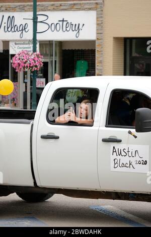 Winterset, Iowa, États-Unis. 31 mai 2020. Les femmes sont acclamées et ont pris des photos pendant la cérémonie de remise des diplômes du 31 mai 2020, à Austin Black, un senior de l'école secondaire Winterset, et leurs familles ont reçu deux véhicules chacun et des blocs de temps ont été attribués par ordre alphabétique. Après avoir parcouru une rue fermée, les aînés ont marché jusqu'aux marches du palais de justice du comté de Madison pour recevoir la reconnaissance et leur diplôme des responsables scolaires. Les écoles Winterset ont indiqué que 146 élèves étaient admissibles à un diplôme. Crédit : Fritz Nordengren/ZUMA Wire/Alay Live News Banque D'Images