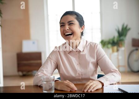 Une jeune femme indienne joyeuse s'est amusée lors d'une entrevue d'emploi. Banque D'Images