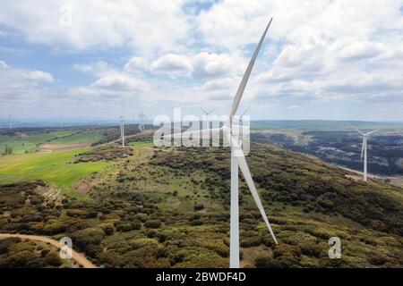 Vue aérienne de la ferme des moulins à vent pour une production d'énergie propre sur un ciel nuageux magnifique. Éoliennes générant de l'énergie propre et renouvelable pour le développement durable . Banque D'Images
