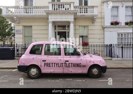 LONDRES, Royaume-Uni -16 MAI 2020 - UN taxi britannique Hackney Carriage peint en rose avec des annonces pour peu de choses dans la rue à Londres, Angleterre. Banque D'Images