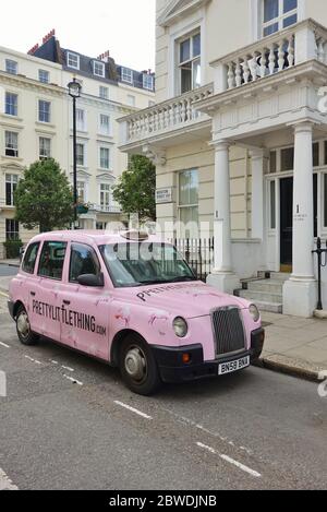 LONDRES, Royaume-Uni -16 MAI 2020 - UN taxi britannique Hackney Carriage peint en rose avec des annonces pour peu de choses dans la rue à Londres, Angleterre. Banque D'Images