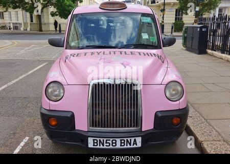 LONDRES, Royaume-Uni -16 MAI 2020 - UN taxi britannique Hackney Carriage peint en rose avec des annonces pour peu de choses dans la rue à Londres, Angleterre. Banque D'Images