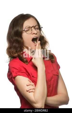 Jolie jeune femme aux cheveux bouclés dans des verres noirs et une chemise rouge qui baigne de l'ennui Banque D'Images