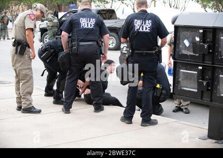 Sous-ville, SOUS-ÉTAT. 31 mai 2020. Après que les responsables de Dallas TX ont déclaré un couvre-feu de 19:00 à 6:00 pendant plusieurs jours dans le centre-ville et les environs, la police d'État de Dallas et de TX ont lancé une application de police agressive sur les manifestants qui marchaient dans la région.près de 100 personnes ont été mises en garde à vue dans les premières heures du couvre-feu. Les officiers BUM-ont précipité beaucoup de personnes qui se sont produites juste pour marcher à proximité.la police de Dallas et la police d'État de TX serrer les liens en plastique sur une femme qui marchait avec un groupe sur Griffin Street juste quelques instants après que le couvre-feu est entré en vigueur à 19h00. (Image crédit: © AVI Adelm Banque D'Images