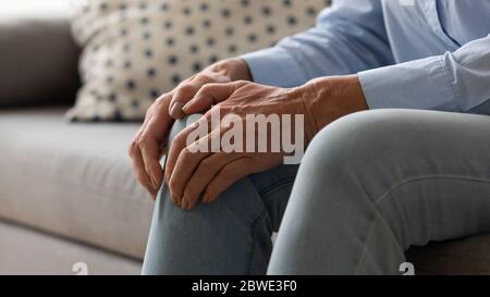 Femme âgée qui ressent une douleur touche le genou image rapprochée Banque D'Images