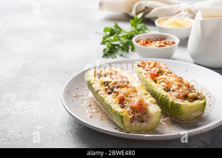 Bateaux de courgettes farcis cuits avec champignons de poulet émincés et légumes avec fromage sur une assiette espace de copie Banque D'Images