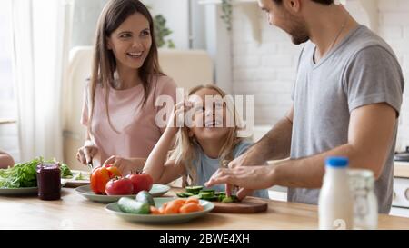 Une famille heureuse avec des enfants qui cuisent des aliments sains à la maison Banque D'Images