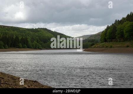 Vue sur le barrage de Howden au loin au-dessus des bois et du réservoir Derwent, dans le Peak District, Royaume-Uni Banque D'Images