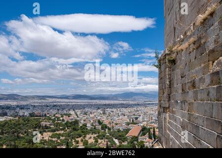 Paysage urbain d'Athènes et temple d'Hephaestus contre ciel bleu nuageux en un jour de printemps. Vue depuis la colline de l'Acropole, partie du mur en pierre de propylaea. Attica, Grèce Banque D'Images