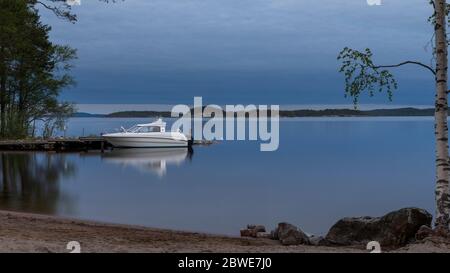 Crépuscule d'été avec bateau à moteur sur le lac Päijänne en Finlande Banque D'Images