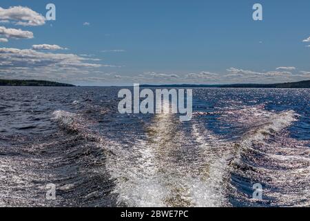 Le bateau à moteur fait une vague de sternes dans le lac finlandais Päijänne, le jour d'été Banque D'Images