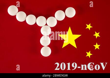 Cellule bactérienne faite de comprimés blancs avec l'inscription 2019- nCoV sur un fond rouge du drapeau chinois, vue du dessus. 2019 Nouveau coronavirus 2019-NC Banque D'Images