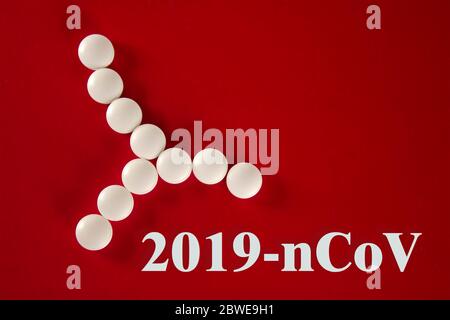 Cellule bactérienne faite de comprimés blancs avec l'inscription 2019- nCoV sur fond rouge, vue de dessus. 2019 Nouveau concept de coronavirus 2019-nCoV. Banque D'Images