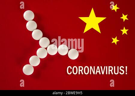 Cellule bactérienne faite de comprimés blancs avec l'inscription CORONAVIRUS sur un fond rouge du drapeau chinois, vue du dessus. 2019 Nouveau coronavirus 2019-n Banque D'Images