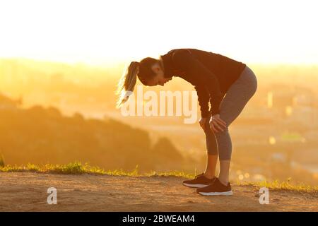 Portrait d'un coureur fatigué en bordure de la ville au coucher du soleil Banque D'Images