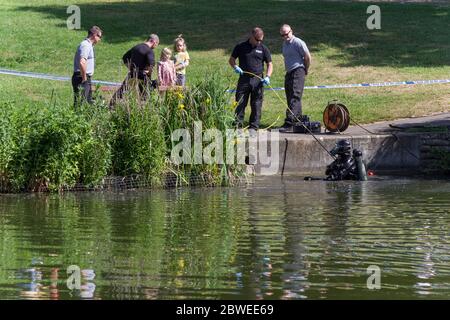 Équipe de plongée de police cherchant le lac après un bout sur une arme; Abington Park, Northampton, Royaume-Uni Banque D'Images