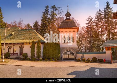 Roumanie, Belfry et porte du monastère de Sinaia au coucher du soleil Banque D'Images