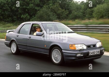 Jackie Stewart pilotant une Ford Sierra Cosworth sur la piste de course 1988 d'Oulton Park Banque D'Images