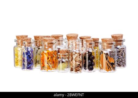Tisane, herbes séchées, fleurs et baies en bouteilles de verre à usage médical sur fond blanc Banque D'Images