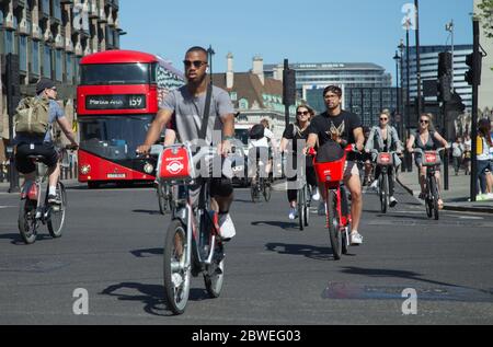 De jeunes cyclistes, dont un homme noir, pédalent sur les vélos Boris près de la place du Parlement à Westminster, Londres, en mai 2020, pendant une pandémie de coronavirus Banque D'Images