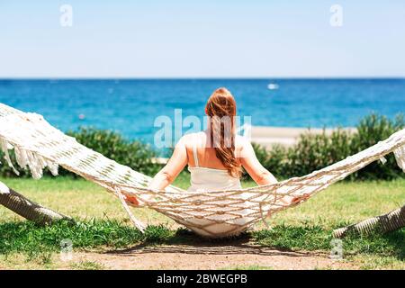 Jeune femme se relaxant dans le hamac sur la plage avec vue sur la mer Banque D'Images