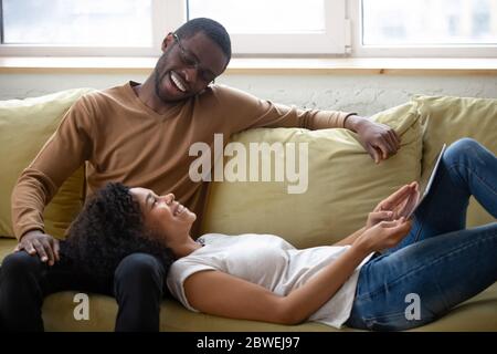 Couple africain reposant sur un canapé profiter d'une conversation agréable Banque D'Images