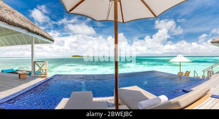 Complexe de luxe avec belle piscine et vue sur la mer sous ciel bleu. Luxueux paysage tropical de plage, chaises longues et chaises longues et reflet de l'eau Banque D'Images