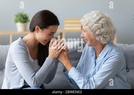Grand-mère âgée petite-fille adulte rire assis sur le canapé profiter de parler Banque D'Images