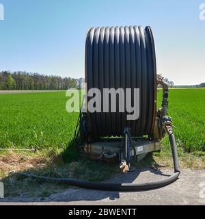 Long tuyau sur un énorme tambour de tuyau qui est utilisé pour irriguer les champs de l'agriculteur Banque D'Images