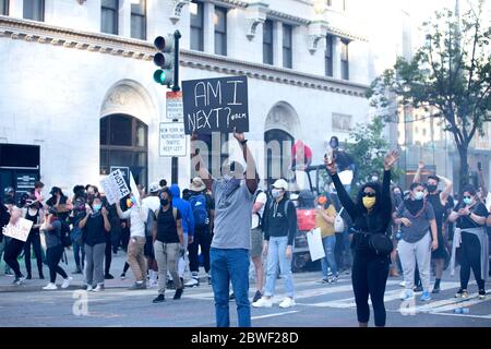 Un manifestant tient un panneau dans une intersection lors d'une manifestation à Washington, DC, États-Unis, le dimanche 31 mai 2020, à la suite de la mort d'un homme noir non armé aux mains de la police du Minnesota, le 25 mai 2020. Crédit : Stefani Reynolds/CNP/MediaPunch Banque D'Images