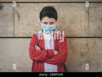 enfant en colère portant un masque médical à l'extérieur Banque D'Images