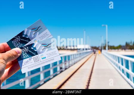 Busselton, 2019 novembre : personne détenant deux billets d'entrée à Busselton Jetty. Train sur la jetée en arrière-plan. Célèbre attraction touristique en Australie Banque D'Images