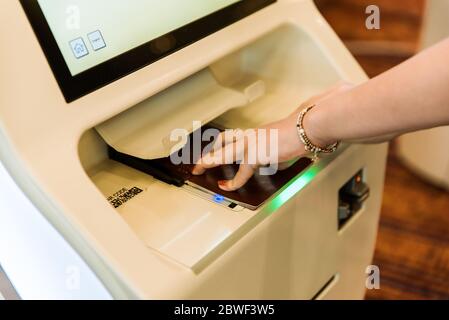 Système d'embarquement électronique en libre-service et lecteur de passeport à l'aéroport. Machine à enregistrement automatique. Impression de la carte d'embarquement pour les passagers Banque D'Images