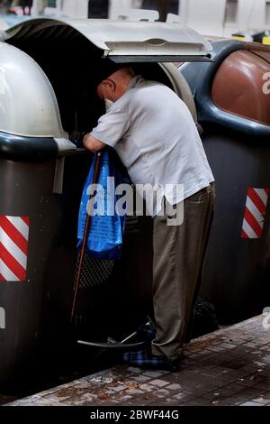 Un vieil homme qui traverse les poubelles, Barcelone, Espagne. Banque D'Images