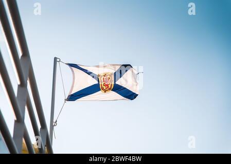 Drapeau de la Nouvelle-Écosse sur un mât métallique sur fond bleu ciel, Canada. Les armoiries de la Nouvelle-Écosse, province canadienne Banque D'Images