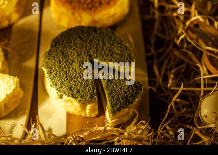 Cheesecake de Matcha coupé en tranches sur bois dans une boulangerie gastronomique. Dessert japonais matcha Banque D'Images