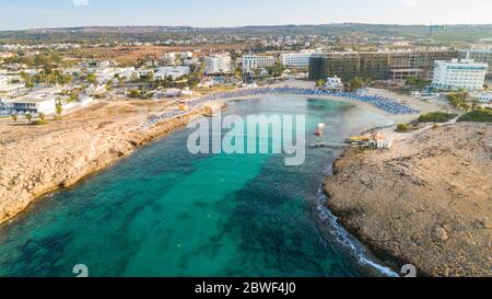 Vue panoramique sur la plage de Vathia Gonia, Ayia Napa, Famagusta, Chypre. L'attraction touristique historique baie rocheuse au lever du soleil avec sable doré, soleil Banque D'Images