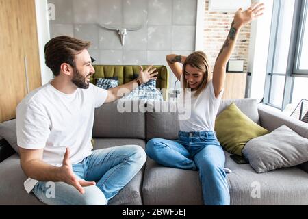 Les jeunes couples se détendent sur leur canapé. Amour, bonheur, personnes et concept amusant. Banque D'Images