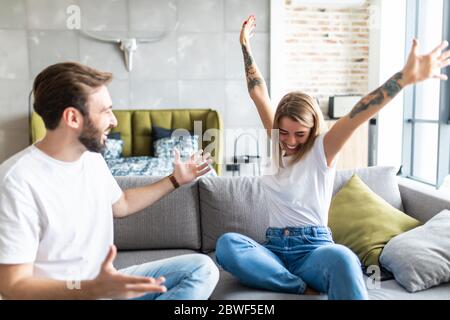 Les jeunes couples se détendent sur leur canapé. Amour, bonheur, personnes et concept amusant. Banque D'Images