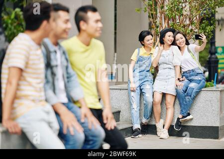 De jeunes étudiants asiatiques souriants prennent leur selfie sur le campus Banque D'Images