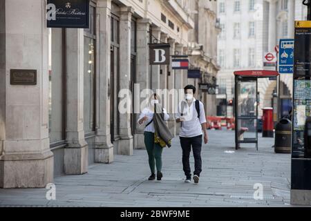 Les touristes se promondent le long d'une rue vide de Regent Street dans le centre de Londres pendant les restrictions de confinement en cas de pandémie de coronavirus, où les magasins ne sont pas ouverts, au Royaume-Uni Banque D'Images