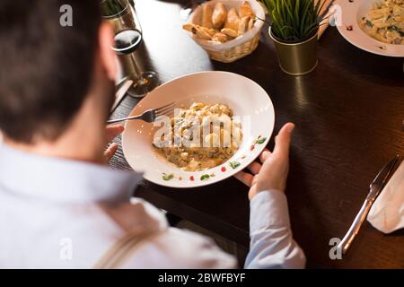 Vue sur le restaurant, un homme mangeant des gnocchi Banque D'Images