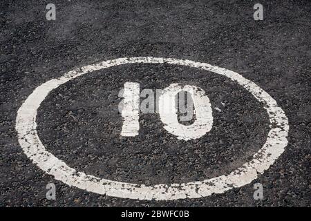 La limite de vitesse numéro 10 à l'intérieur d'un cercle peint sur une route tarmac Banque D'Images