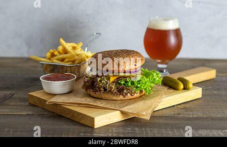 Hamburger maison avec bière artisanale, cornichons et frites Banque D'Images