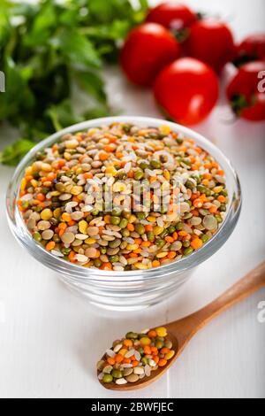 Grains ou lentilles colorés et graines entières ou céréales dans un bol avec légumes frais. Banque D'Images