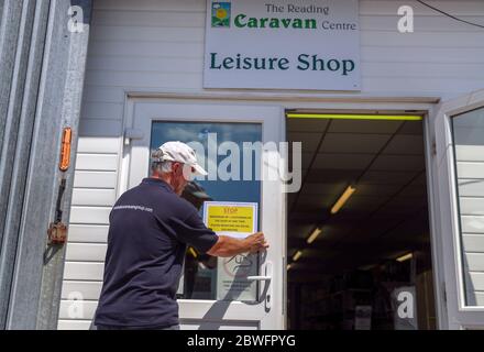 Ian Stamp met des signes de distanciation sociale au Reading Caravan and Motorhome Center après l'introduction de mesures pour soulager l'Angleterre hors de son verrouillage. Banque D'Images