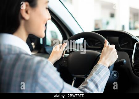 Jeune femme de race blanche conduisant sa nouvelle voiture Banque D'Images